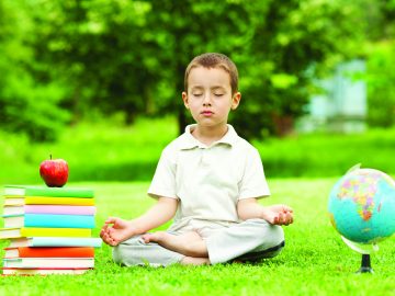 Little boy in zen meditation preparing to be good student