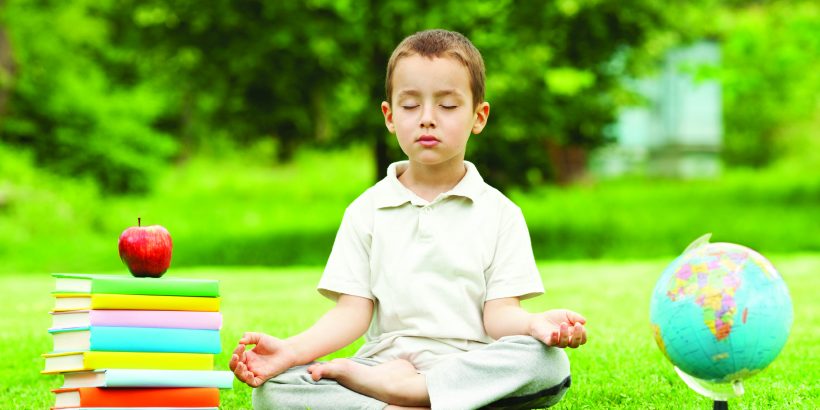 Little boy in zen meditation preparing to be good student